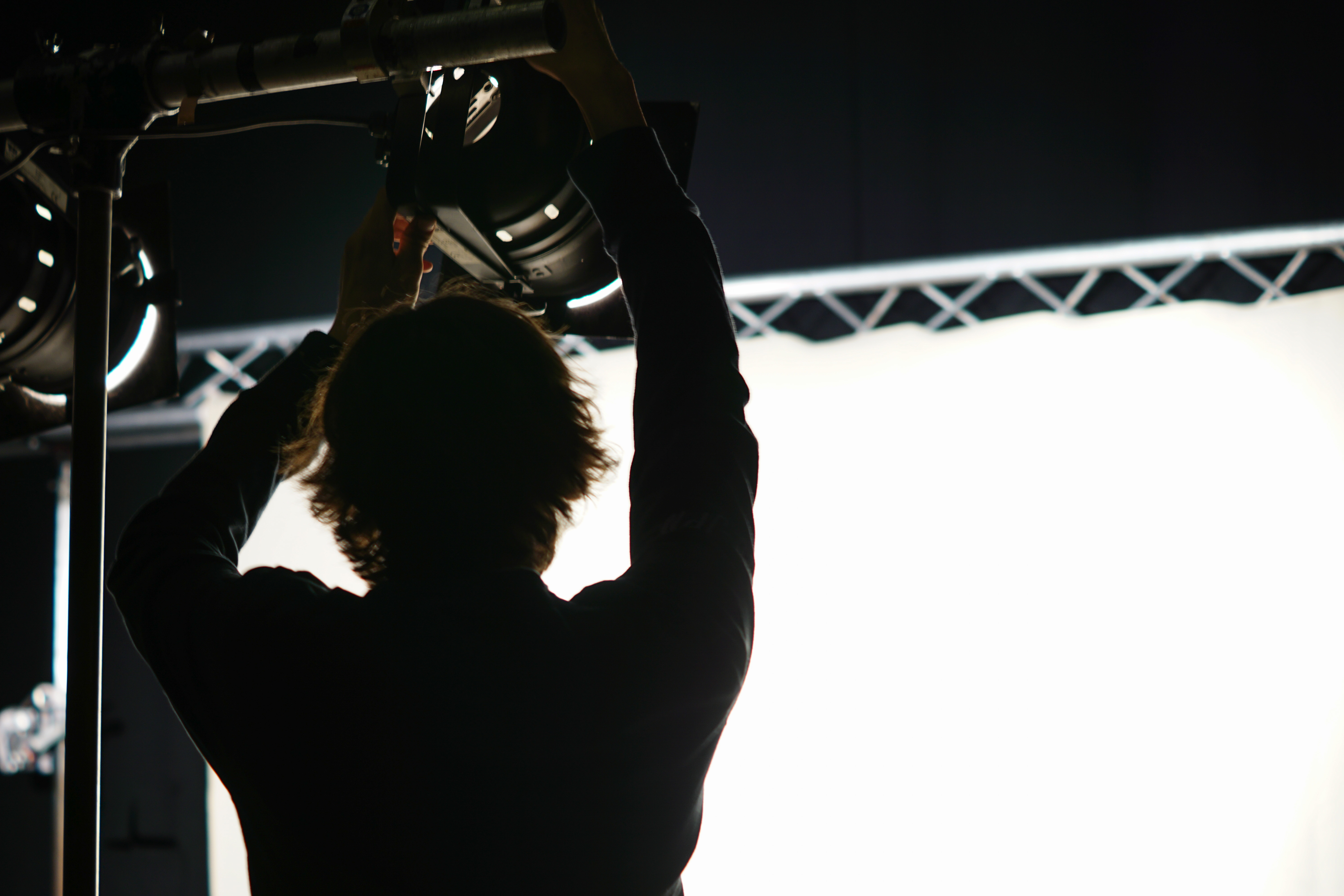 Silhouetted person focusing a light